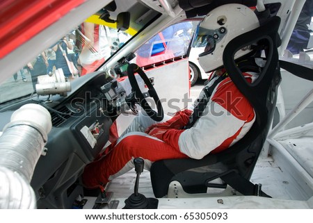 Interior of touring car for racing on race circuits with driver in the seat