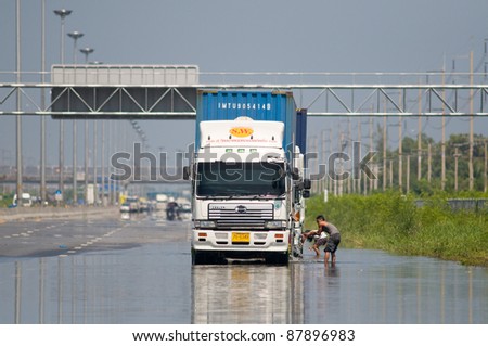 BANGKOK, THAILAND - NOVEMBER 1: Drivers clean their trucks at one of Bangkok\'s motorways during the worst flooding in decades in Bangkok, Thailand on November 1, 2011.