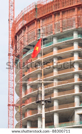 Building under construction in Vietnam with the Vietnamese flag in the foreground.