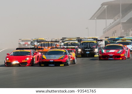 DUBAI - JANUARY 13: 75 cars coming down the dusty start-finish straight at the start of the 2012 Dunlop 24 Hour Race at Dubai Autodrome on January 13, 2012.