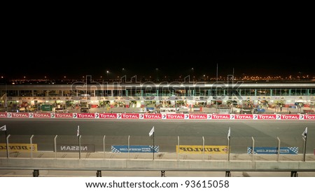 DUBAI - JANUARY 13: Start-finish straight and pit lane of the track with city lights in the background during the 2012 Dunlop 24 Hour Race at Dubai Autodrome on January 13, 2012 in Dubai.