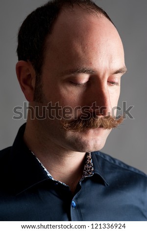 Grunge portrait of a handsome young man with his eyes closed and in thought looking downwards