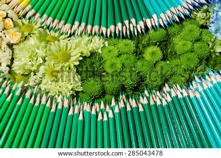 Background of colorful flowers and pencils with a green tint