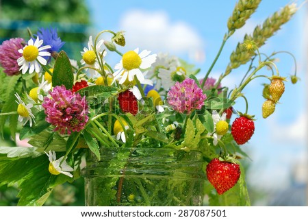Bouquet of wild flowers and strawberries