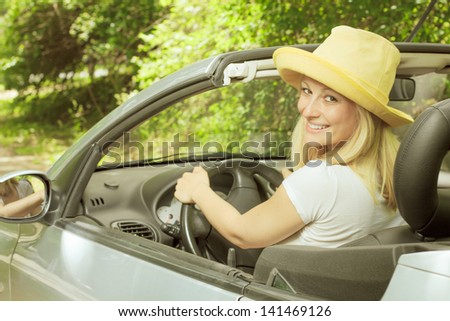 Cheerful beautiful young woman in the car.