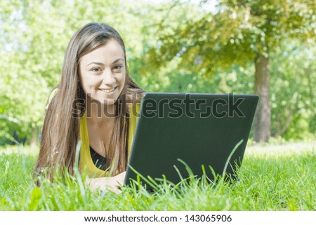 Happiness teen girl using laptop in the nature.