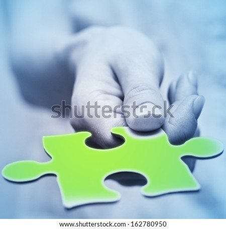 Human hands holding the missing piece .