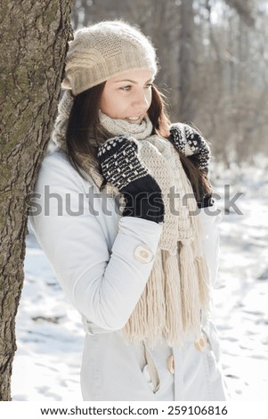 Smiling Lovely Young Woman Winter Portrait at beautiful sunny winter day in the park. Happy Caucasian female wintertime season outdoor.