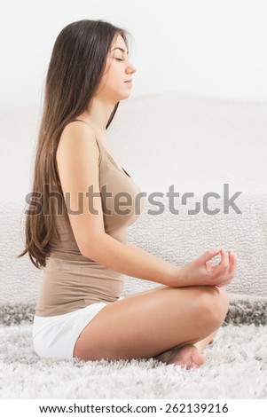 Young Woman Doing Yoga Meditation at home. Caucasian female relaxing .  Healthy Lifestyle.