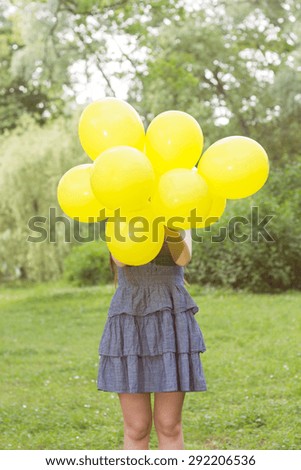 Happy Young Woman with Yellow Balloons at beautiful Summer Day Outdoor. Attractive female enjoying nature.