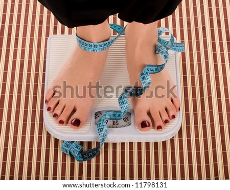 Woman foot on measuring tape.