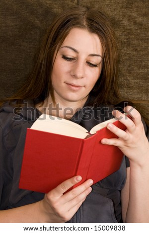 Young beautiful student read book on couch.