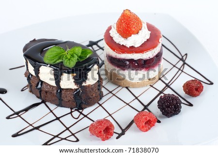 Desserts with chocolate topping and fruit on the plate.
