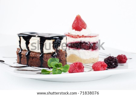 Desserts with chocolate topping and fruit on the plate.