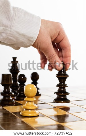 Human hand move black king on chessboard.