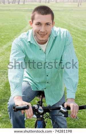 Young man on bike relaxing outdoors.
