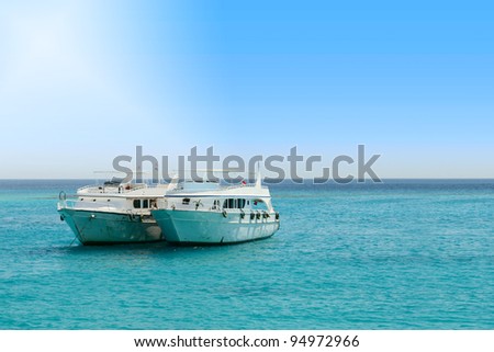 Two tourist boats in the middle of the sea with space for your message.