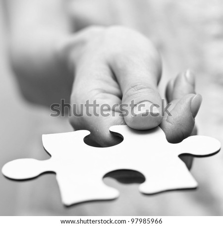 Human hands holding the missing piece .