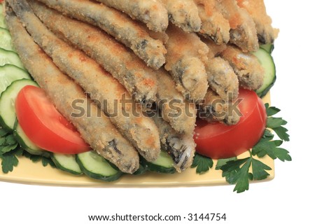 Fried fish with sliced cucumbers, tomatoes and parsley, isolated on white background