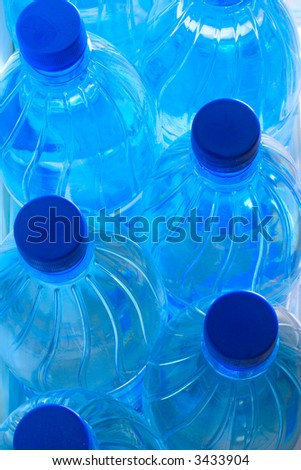 Blue plastic bottles with spring water, top view