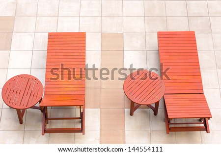 empty poolside deckchairs with beautiful blue swimming pool from top view