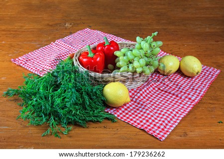 Still life with Summer fruit and vegetables on a red gingham cloth.