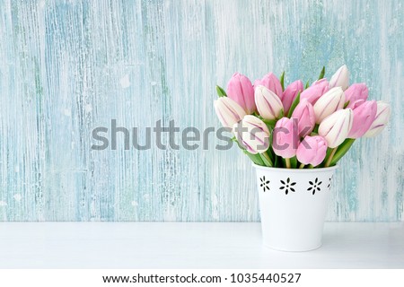 Pink tulips bouquet in white vase on light blue background. Holiday background, copy space. Valentine Day, Mothers day, birthday concept.