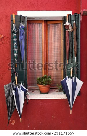 Old window with umbrellas. Burano. Venice. Italy