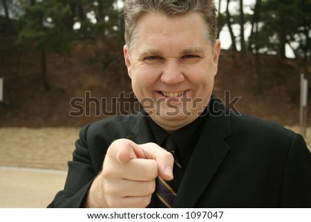 a businessman gives the i want you point.