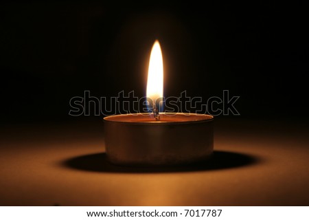 Single candle in dark in portrait