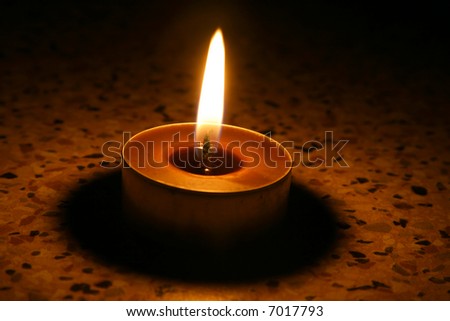 Single candle in dark in portrait