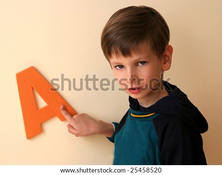 Boy playing with letter A, focused on face