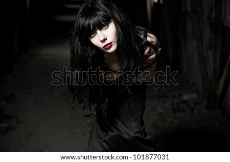 Closeup portrait of beautiful goth girl in the dark tunnel