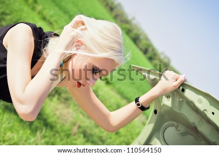 Blonde girl stands by the broken car and don\'t know what to do
