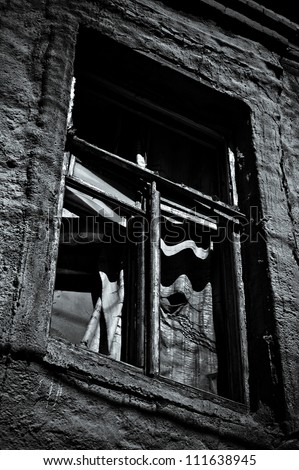Window of abandoned house. Black and white photo in low key
