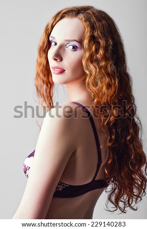 Closeup studio portrait of attractive ginger woman. Half-turned, high key