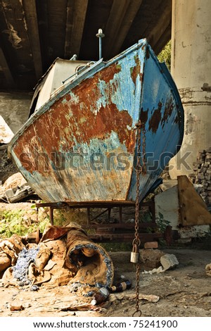 The old rusty boat under the bridge