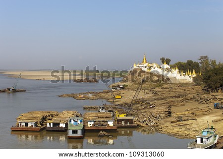 chop wood immerse to barge and transport near the buddhist temple, Myanmar