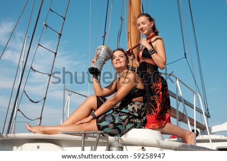 two beautiful women on the yacht with music instruments