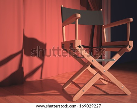 Director\'s chair on the stage illuminated by floodlights.