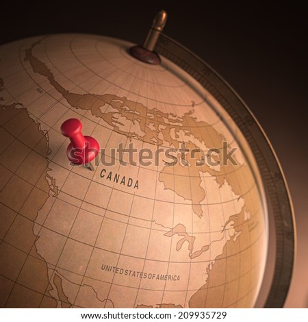 Antique globe with the Canada marked by the pin. Clipping path included.