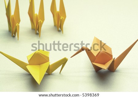 Leadership concept. The orange bird commands all the other birds.   In the Japan, Tsuru origami represents luck, peace, happiness and longevity.