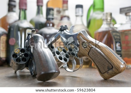 Two weapons with only one bullet each. At the bottom a few bottles of whiskey. Concept of challenge and test of courage.