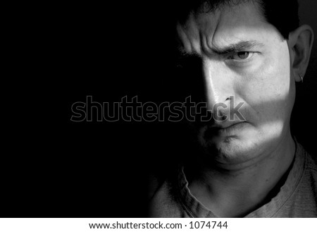 Black and white photo of a man with a furrowed brow and a doubtful look on his face.