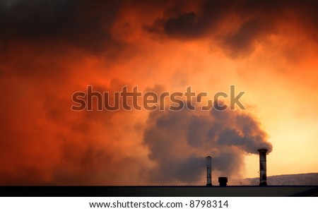 Steam or smoke billowing from chimneys on a cold day at dawn.