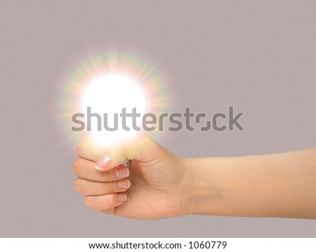 Female hand holding a shining light bulb