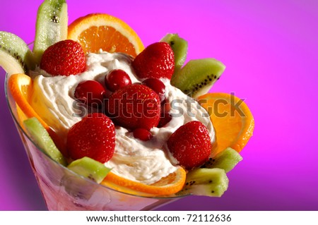 Martini glass filled with colorful fruit ice cream isolated on pink background