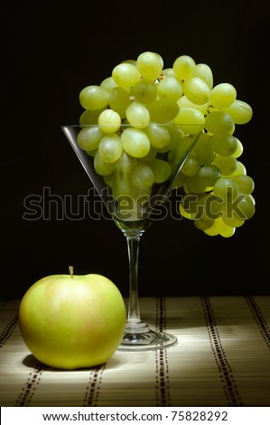 Grapes in a martini glass and an apple Artistic light-painted food still life