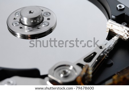 Close-up of a working hard disk drive with blurred rotating spindel and parked heads