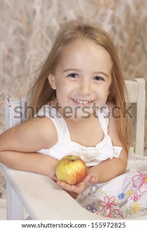 Country setting for this school girl with a smile and holding an apple